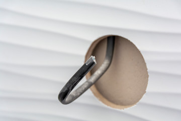 Hole in the wall with ceramic tiles with protruding wires for the outlet. Hole for the outlet. Tiled wall.