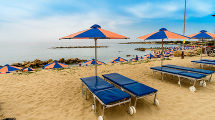 sun loungers on the beach of the mediterranean sea cyprus, new beach season, time to go on vacation