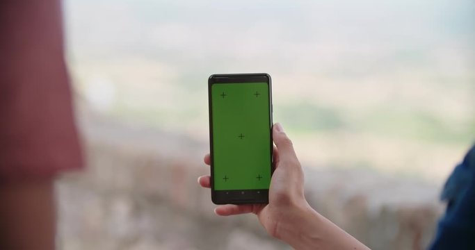 Romantic couple taking a selfie or using green screeen smartphone device in rural town of Assisi.Portrait medium shot.Friends italian trip in Umbria.4k slow motion