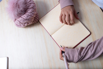 persona escribiendo en una agenda con pluma o bolígrafo colores palo de rosa