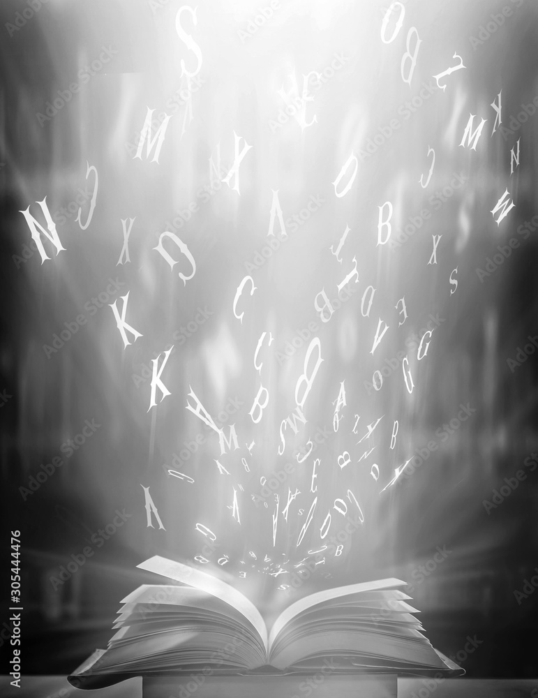 Poster imagine opening an old book blurred with magic power on the table and the english alphabet floating 