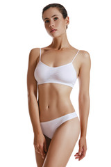 Fototapeta premium Young woman in white underwear, with bundled hair, posing in studio, isolated on white. Plastic surgery, aesthetic cosmetology. Close-up.
