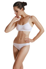 Fototapeta premium Young woman in white underwear, with bundled hair, posing in studio, isolated on white. Plastic surgery, aesthetic cosmetology. Close-up.