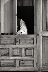 Priest in confessional confessing to a faithful