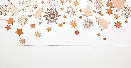 The beautiful christmas background with a lot of small wooden decorations on the white wooden desk.