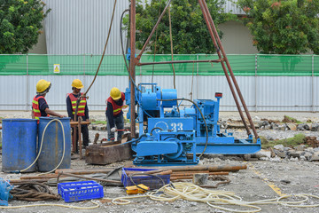 Construction workers drilling obtaining soil samples field for geological logging, analysis and...