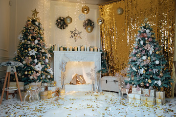 Beautiful classic golden Christmas room decor. Christmas studio interior. New Year's gifts, trees, decorations. Happy New Year. Christmas trees with New Year s balls and a garland.