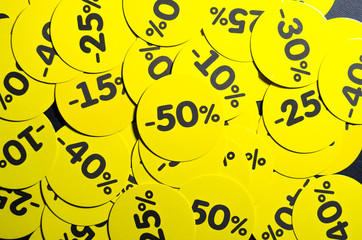Yellow round stickers with discounts of 10 to 50 percent. Sell-out. Discounts on a black background. Black Friday. Price fall. Posters. Macro discounts.