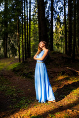 Obraz na płótnie Canvas Beautiful woman in blue dress in the forest in autumn day