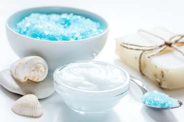 blue sea salt, soap and body cream on white desk background