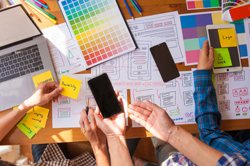 Obraz premium The web designer team is helping to design applications for mobile phones. UX UI designer concept