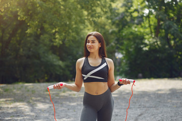 Beautiful girl training. Sports girl in a sportswear. Brunette with jump rope