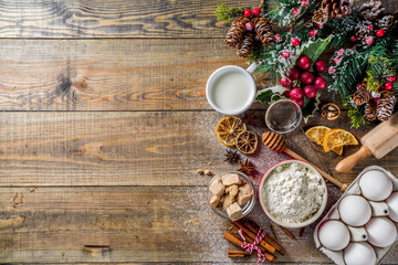 Christmas baking background. Ingredients for cooking xmas baking. Flour, eggs, sugar, berry, spices on wooden background with christmas decor,. Top view copy space.