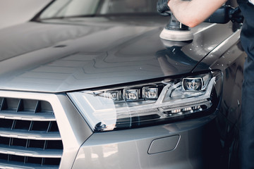 Obraz premium Man in a garage. Worker polish a car.