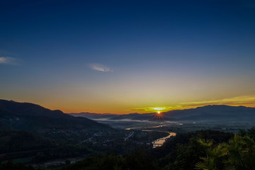 Obraz premium Mountain view misty morning above Kok river and Tha Ton City around with soft mist in valley and blue sky background, sunrise at Wat Tha Ton, Tha Ton District, Fang, Chiang Mai, northern of Thailand.