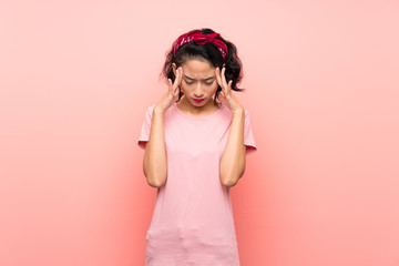 Asian young woman over isolated pink background with headache