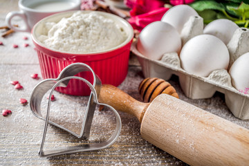 Valentine day baking background. Ingredients for cooking Valentine's heart cookies. Flour, eggs,...