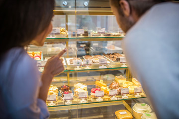 Businessmen looking at fridge with amazing desserts together