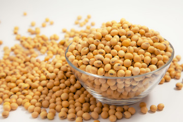 Soybeans background . Dry Soy bean or soya bean in a bowl with some soybeans in wooden spoon on white background