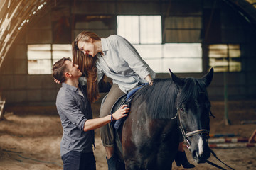 Couple on a ranch. Pair standing with a horse. Girl with her boyfriend