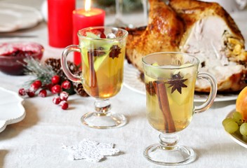 christmas hot cider. hot winter drink Cranberry Apple Cider Punch. Garnish with apples, oranges, and cranberries. hot apple cider with spices on a festive table on Christmas or New Year.