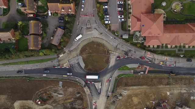 Wide top down aerial view of a newly constructed roundabout, with traffic being managed as contraflows.