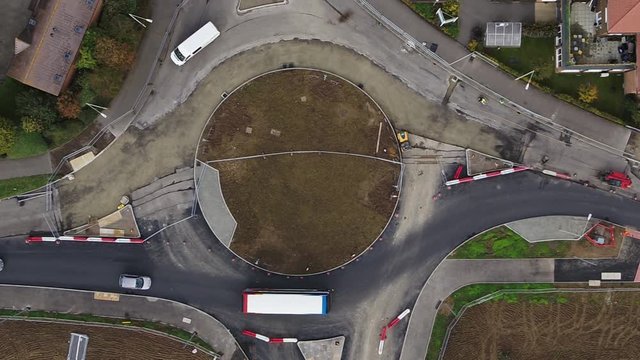 Tight top down aerial view of a newly constructed roundabout, with traffic being managed as contraflows.