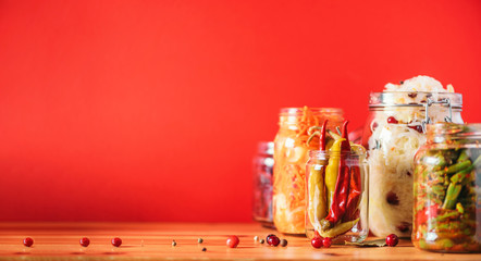 Probiotics food background. Korean carrot, kimchi, beetroot, sauerkraut, pickled cucumbers in glass jars. Winter fermented and canning food concept. Banner with copy space
