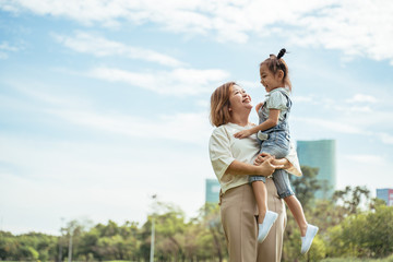 Nice little girl run to grandmother's hug in park.Grandmother and grand daughter enjoying sunny...