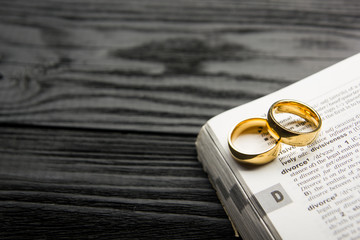 Divorce and separation concept. Two golden wedding rings. Dictionary definition