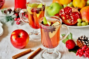 hot winter drink Cranberry Apple Cider Punch. Garnish with apples, oranges, and cranberries. hot apple cider with spices on a festive table on Christmas or New Year.