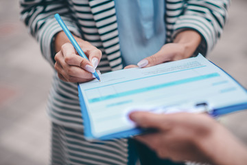 Close up of woman putting signature after getting her parcel