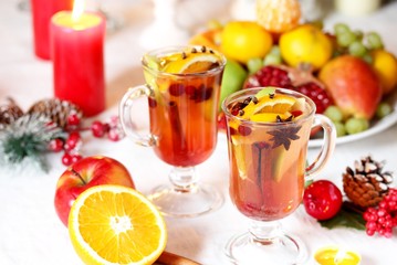 hot winter drink Cranberry Apple Cider Punch. Garnish with apples, oranges, and cranberries. hot apple cider with spices on a festive table on Christmas or New Year.