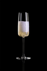 Champagne on black backgroundA glass of champagne isolated on a black background. The glass is half full.