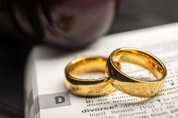 Divorce and separation concept. Two golden wedding rings. Dictionary definition