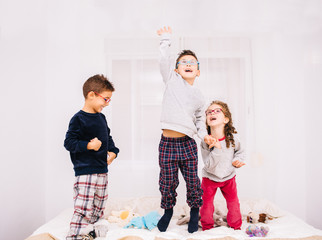 Children playing on a bed.