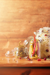 Assortment of various fermented and marinated food over wooden background, copy space. Fermented vegetables, sauerkraut, pepper, garlic, beetroot, korean carrot, cucumber kimchi in glass jars.