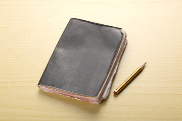 old agenda and a pencil rest on a wooden table with copy space for your text