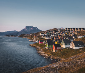 Nuuk capital of Greenland with Beautiful small colorful houses in myggedalen during Sunset Sunrise Midnight Sun. Sermitsiaq Mountain in Background. Blue and pink Sky. © Mathias