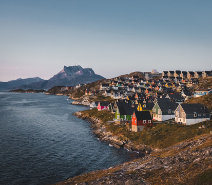 Nuuk capital of Greenland with Beautiful small colorful houses in myggedalen during Sunset Sunrise Midnight Sun. Sermitsiaq Mountain in Background. Blue and pink Sky.