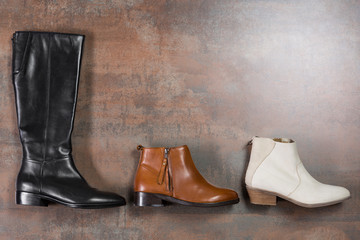 women's winter or autumn shoes laid out in a row, concept, high black boots and leather shoes