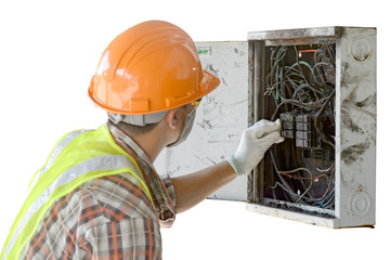 The electrician is checking the electrical control cabinet that is on fire.