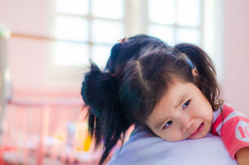 An Asian kindergarten girl is embracing her mother with sadness.