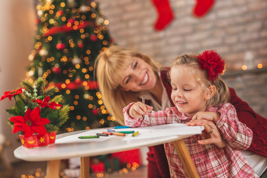 Mother and daughter making a drawing for Santa