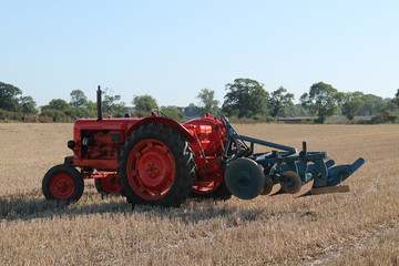 A Vintage Tractor and Plough in a Farming Field.