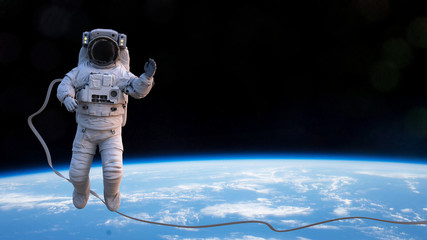 astronaut waving in orbit of planet Earth © dottedyeti