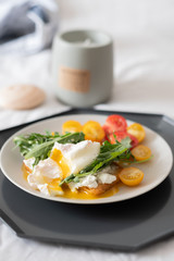 beautiful delicious breakfast, cherry tomatoes, greens and poached egg. 
