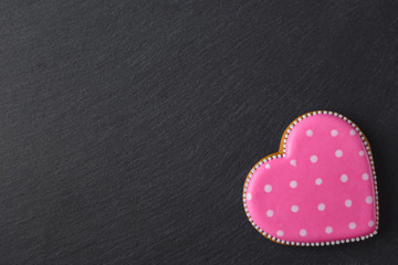 Pink cookie heart shaped with different patterns, black slate stone background