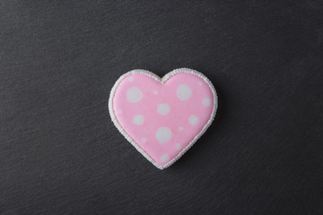 Pink cookie heart shaped with different patterns, black slate stone background