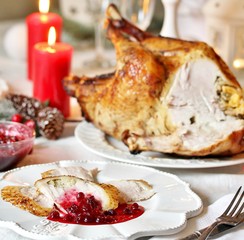 Christmas turkey with cranberry sauce on the holiday table and candles